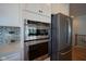 Modern kitchen featuring stainless steel double oven, refrigerator, and white cabinets with contrasting countertops and tile backsplash at 16235 Natures Way, Westfield, IN 46074