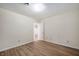 A bright bedroom featuring wood-look floors, neutral walls, and an open doorway at 2009 N New York Ave, Muncie, IN 47304