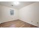 A bedroom with wood-look floors, light walls, and a sunny window at 2009 N New York Ave, Muncie, IN 47304
