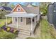 Attractive home with covered front porch, steps, and colorful flower beds enhancing its curb appeal at 2026 E 10Th St, Indianapolis, IN 46201