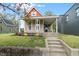 Quaint home boasting a welcoming front porch, colorful flower beds, and classic curb appeal at 2026 E 10Th St, Indianapolis, IN 46201