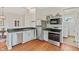 The kitchen features a stainless steel dishwasher and refrigerator, hardwood floors, and gray cabinets at 2026 E 10Th St, Indianapolis, IN 46201