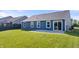 Home's exterior featuring a dark blue siding, back patio, and a spacious, green lawn at 216 Haywood Rd, Greenwood, IN 46142