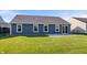 Rear view of home featuring dark blue siding, bright white trim, patio and spacious backyard at 216 Haywood Rd, Greenwood, IN 46142