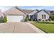 Inviting home featuring a two-car garage, well-maintained lawn and a cozy front entryway at 216 Haywood Rd, Greenwood, IN 46142