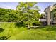 Exterior shot of the home surrounded by a well-maintained lawn and mature trees at 2247 Frisco Pl, Indianapolis, IN 46240
