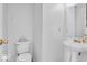 Bathroom featuring a toilet, pedestal sink, and a mirror, all in a minimalist style at 2309 Westmere Dr, Plainfield, IN 46168
