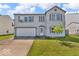 Two-story home with a white two car garage door, complemented by a front yard tree at 2309 Westmere Dr, Plainfield, IN 46168