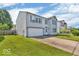 Two-story home featuring an attached two-car garage, a cozy front porch and green lawn at 2309 Westmere Dr, Plainfield, IN 46168