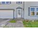 Close-up of the front door with sidelights, two-car garage and green lawn at 2309 Westmere Dr, Plainfield, IN 46168