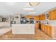 Open kitchen boasts wood cabinets, black appliances, light countertops, and views of the carpeted living room at 2309 Westmere Dr, Plainfield, IN 46168