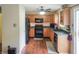 Traditional kitchen features wood cabinets, black appliances, and a tile backsplash at 2355 Collins Way, Greenfield, IN 46140