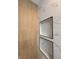 A close up on the detail on the shower with a tiled shower area that includes built-in shelving at 2543 Union St, Indianapolis, IN 46225