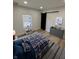 Bedroom with a blue and plaid comforter, dark gray dresser, and a sliding black barn door at 2543 Union St, Indianapolis, IN 46225