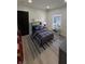 Bedroom with a blue and plaid comforter, dark gray bed frame, a sliding black barn door, and wood-style flooring at 2543 Union St, Indianapolis, IN 46225