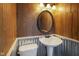 Rustic half-bathroom featuring wood paneling and a pedestal sink complemented by an oval mirror at 2911 N 200 W Rd, Franklin, IN 46131