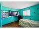 Bright teal bedroom with mounted TV, fun character wall decor, and a zig-zag patterned bedspread at 2911 N 200 W Rd, Franklin, IN 46131