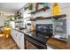 Well-lit kitchen with white cabinets, modern appliances, and rustic shelving for decorative display at 2911 N 200 W Rd, Franklin, IN 46131
