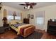 Inviting bedroom with warm tones, hardwood floors, ceiling fan, and natural light at 3059 Tansel Rd, Indianapolis, IN 46234
