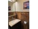 Compact bathroom with a decorative wood backsplash, updated fixtures, and quirky decor at 31 S Sugar Creek Dr, New Palestine, IN 46163