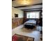 Comfortable bedroom with wood-paneled walls, a large window, and ample natural light at 31 S Sugar Creek Dr, New Palestine, IN 46163