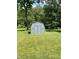 A shed sits in the middle of a green lawn surrounded by lush trees at 31 S Sugar Creek Dr, New Palestine, IN 46163