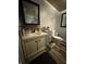 This bathroom features a wood floor, a vintage vanity with marble top, and a toilet with matching decor at 3301 S Lockburn St, Indianapolis, IN 46221