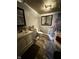 This spacious bathroom features a vintage vanity, wood floors, and a corner tub with stone style tile at 3301 S Lockburn St, Indianapolis, IN 46221