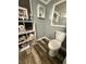 This bathroom features shelving with towels and supplies near the toilet with wood plank flooring at 3301 S Lockburn St, Indianapolis, IN 46221