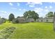 Wide backyard view with a large grassy area, trees, and multiple outbuildings at 3304 Coffey St, Indianapolis, IN 46217