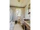 Outdated bathroom with a tub, toilet, sink, and window with tattered lace curtains at 3304 Coffey St, Indianapolis, IN 46217