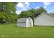 Backyard shed on a grassy lawn with trees and a building in the background at 3304 Coffey St, Indianapolis, IN 46217