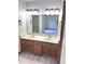 Double vanity bathroom with wood cabinets, matching mirrors, and classic lighting fixtures at 3975 Keyway Dr, Greenwood, IN 46143