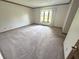 Comfortable bedroom featuring neutral carpet, trim, and a large window overlooking the yard at 3975 Keyway Dr, Greenwood, IN 46143