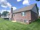 Exterior view of a brick home featuring a deck, a chimney, and well-maintained landscaping at 3975 Keyway Dr, Greenwood, IN 46143
