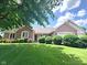 Beautifully landscaped front yard with lush green grass, mature trees, and a classic brick home at 3975 Keyway Dr, Greenwood, IN 46143