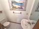Bright powder room featuring sink, toilet, and beach-themed decor at 3975 Keyway Dr, Greenwood, IN 46143