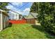 Backyard featuring lawn, red fence, greenery and view of houses at 5430 N Kenwood Ave, Indianapolis, IN 46208