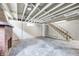 Unfinished basement featuring exposed ceiling, brick fireplace, and access stairs at 5430 N Kenwood Ave, Indianapolis, IN 46208