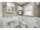 Charming bathroom featuring a pedestal sink, new toilet, and decorative geometric floor tiling at 5430 N Kenwood Ave, Indianapolis, IN 46208