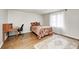 A bright bedroom featuring neutral walls, hardwood floors, and a vintage desk with ample workspace at 5430 N Kenwood Ave, Indianapolis, IN 46208