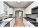 This kitchen has white cabinetry, stainless steel appliances and sink, and tiled floors at 5430 N Kenwood Ave, Indianapolis, IN 46208