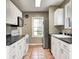 A functional kitchen features a stainless fridge, white cabinets, black counters, and unique backsplash at 5430 N Kenwood Ave, Indianapolis, IN 46208