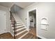 A stairway has wood treads, decorative metal railing and offers a view into kitchen at 5430 N Kenwood Ave, Indianapolis, IN 46208