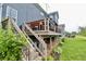 Spacious back deck, wooden stairs, lush green lawn and landscape create great outdoor space at 5473 Forest Glen Dr, Brownsburg, IN 46112