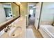 Elegant bathroom with double vanity, quartz countertop, and soaking tub, flowing into the main bedroom at 5473 Forest Glen Dr, Brownsburg, IN 46112