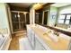 Bright bathroom with double sinks, tile floors, granite countertops, and a separate tub and shower at 5473 Forest Glen Dr, Brownsburg, IN 46112