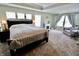 Primary bedroom with tray ceiling, multiple windows, and cozy sitting area at 5473 Forest Glen Dr, Brownsburg, IN 46112