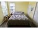 Cozy bedroom featuring a bed with a gray comforter, a window with blinds, and a small table at 5473 Forest Glen Dr, Brownsburg, IN 46112