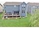 Aerial view of a backyard with a deck, patio, lush landscaping, and vibrant green lawn at 5473 Forest Glen Dr, Brownsburg, IN 46112